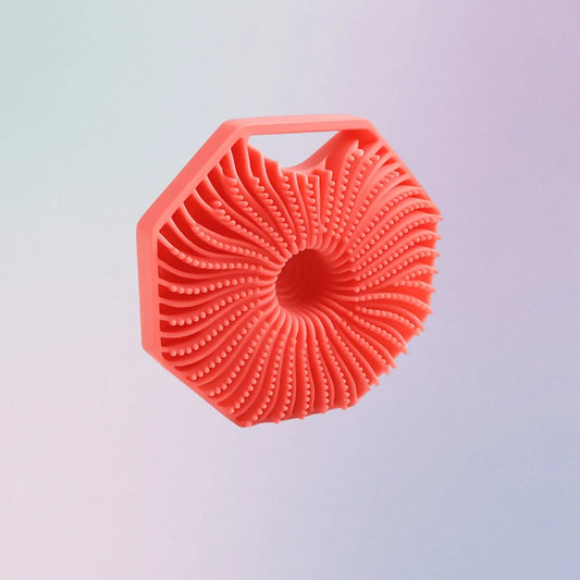 Pink silicone scrubber on a light gray background