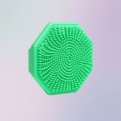 Green silicone face scrubber with soft bristles and finger grip