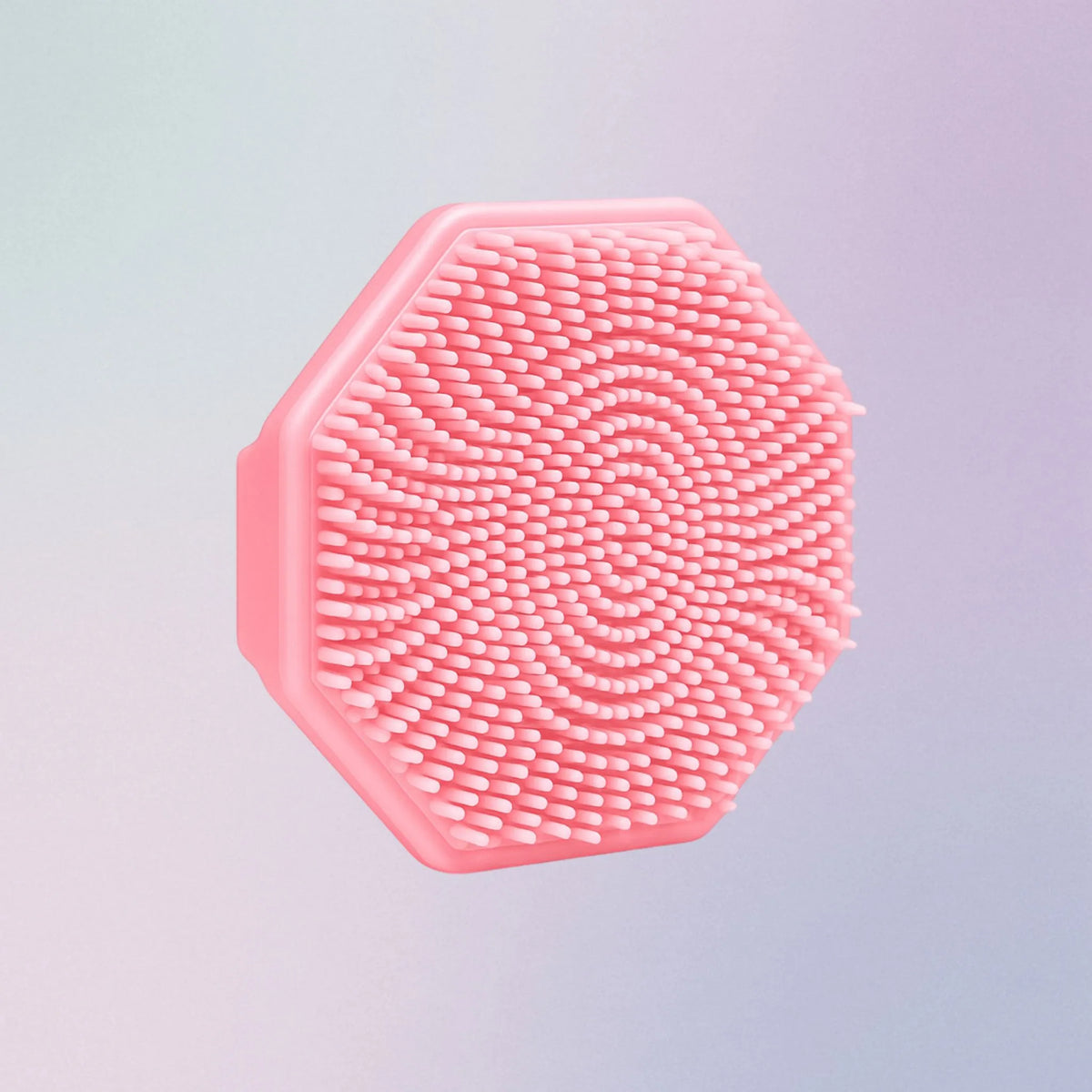 Pink silicone face scrubber with soft bristles and finger grip