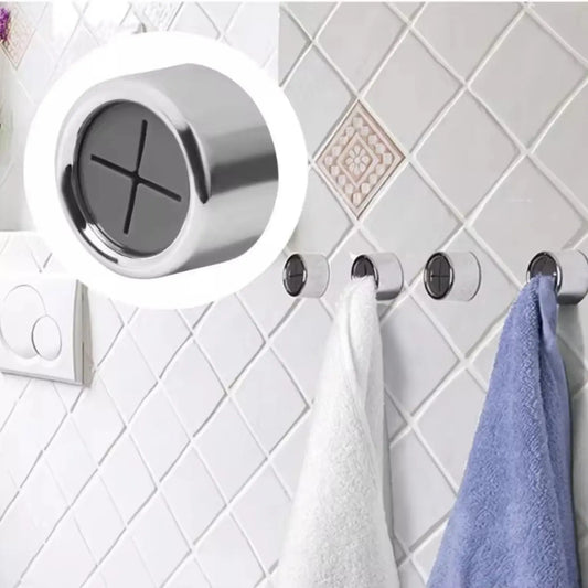 Metallic wall hook with a white towel and blue towel on a tiled bathroom wall.